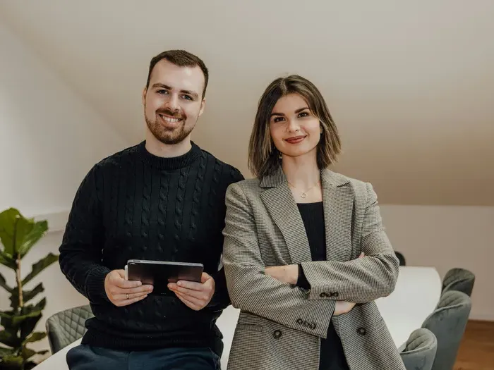 Portrait of two local business owners standing together in a bright modern office, friendly and professional